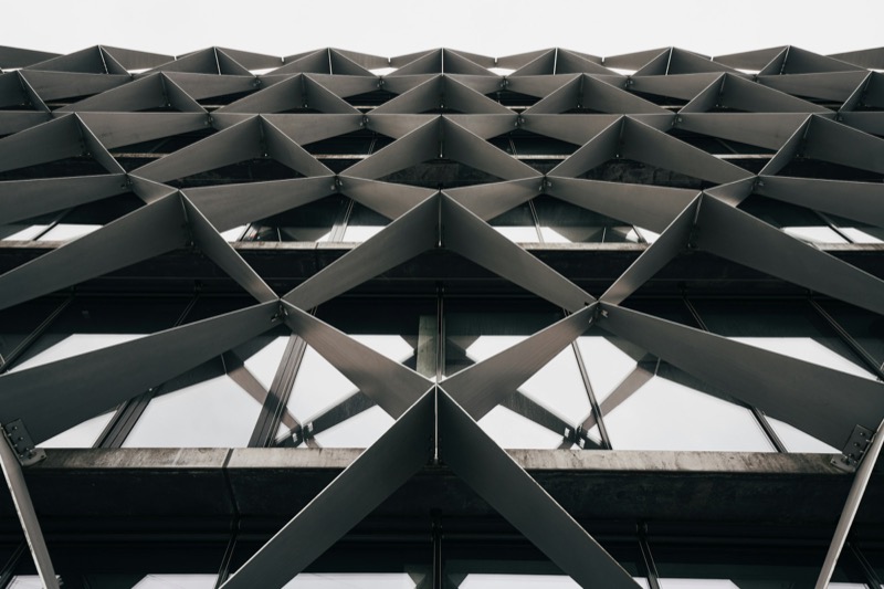 Close-up of a dark geometric steel lattice forming an architectural facade